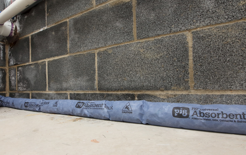 Basement wall with absorbent sock